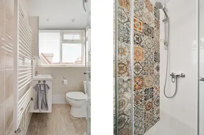 a white bathroom with a toilet and a shower at Hello Noordwijk - Quarles 43 in Noordwijk aan Zee