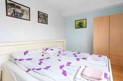 a bedroom with a bed with purple flowers on it at Amsterdam Edge Haven in Purmerend
