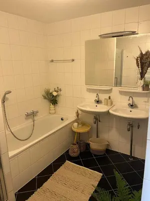 a bathroom with a tub and two sinks and a bath tub at A few steps away apartment in Zandvoort
