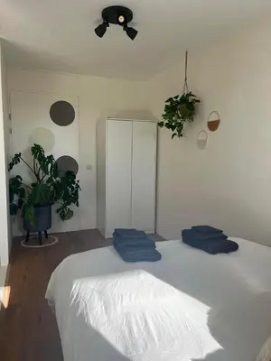 a bedroom with a bed with two blue pillows on it at A few steps away apartment in Zandvoort