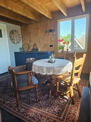 a kitchen with a table and chairs and a window at De Gouwe Hooiberg in Hoogwoud
