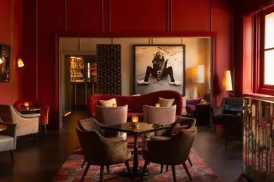 a living room with a couch and a table and chairs at Rosewood Amsterdam in Amsterdam