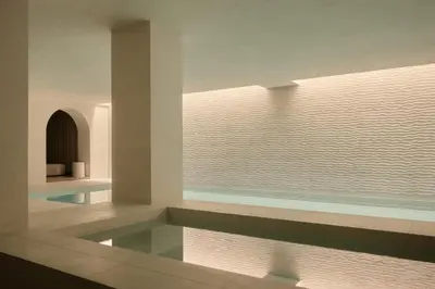 a swimming pool in a room with a window at Rosewood Amsterdam in Amsterdam