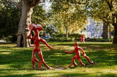 two metal statues of men running in a park at Rosewood Amsterdam in Amsterdam