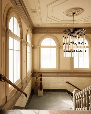 a large room with a chandelier and windows at Rosewood Amsterdam in Amsterdam