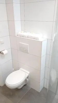 a white bathroom with a toilet and towels at Bright room with kitchen in Amsterdam