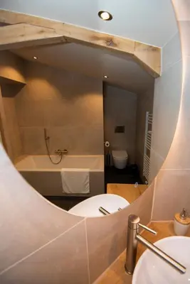a bathroom with a sink and a tub and a mirror at Westeindercabin, rustige locatie maar naast Amsterdam & Schiphol in Aalsmeer