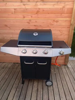 a barbecue grill sitting on a wooden deck at Westeindercabin, rustige locatie maar naast Amsterdam & Schiphol in Aalsmeer