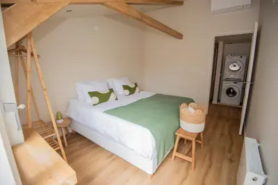 a bedroom with a large bed with a green blanket at Westeindercabin, rustige locatie maar naast Amsterdam & Schiphol in Aalsmeer