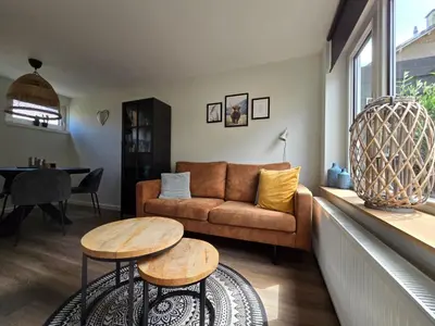 a living room with a couch and two tables at Beach 44 in Egmond aan Zee