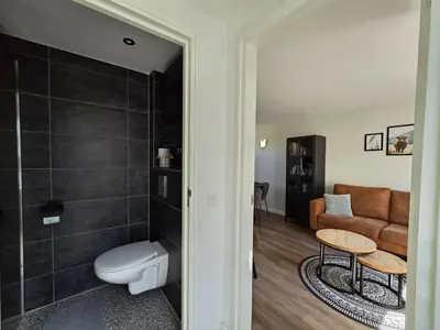 a living room with a toilet and a couch at Beach 44 in Egmond aan Zee