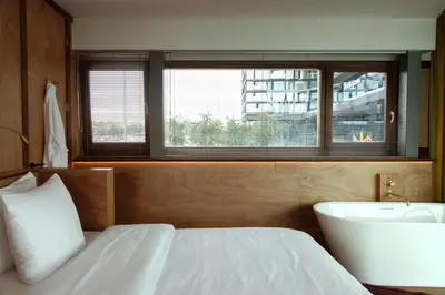 a bedroom with a bed and a tub and a sink at SWEETS - Oosterdoksdraaibrug in Amsterdam