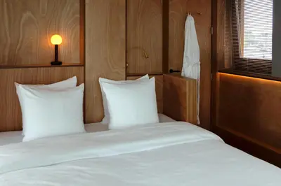a bedroom with a bed with white sheets and a window at SWEETS - Oosterdoksdraaibrug in Amsterdam