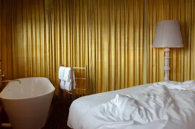 a hotel room with a bed and a white tub at SWEETS - Oosterdoksdraaibrug in Amsterdam