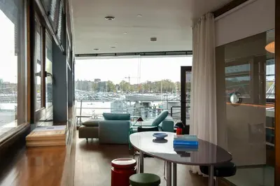 a living room with a table and a view of a marina at SWEETS - Oosterdoksdraaibrug in Amsterdam