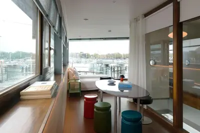a living room with a table and a large window at SWEETS - Oosterdoksdraaibrug in Amsterdam