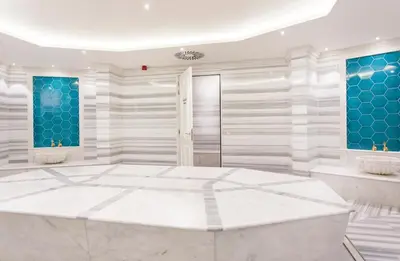 a large bathroom with a marble floor and blue accents at Corendon Amsterdam New-West, a Tribute Portfolio Hotel in Amsterdam