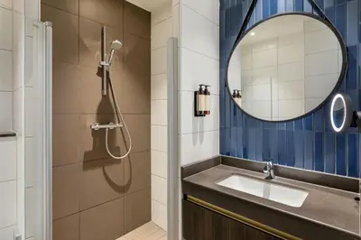 a bathroom with a sink and a mirror at Corendon Amsterdam New-West, a Tribute Portfolio Hotel in Amsterdam