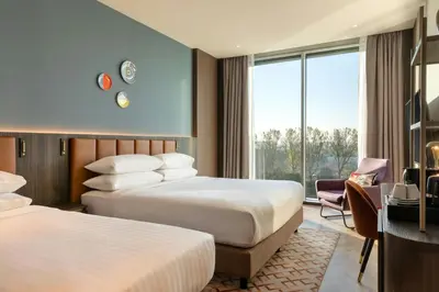a hotel room with two beds and a desk at Corendon Amsterdam New-West, a Tribute Portfolio Hotel in Amsterdam