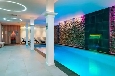 a swimming pool in a hotel lobby with a spa at Corendon Amsterdam New-West, a Tribute Portfolio Hotel in Amsterdam