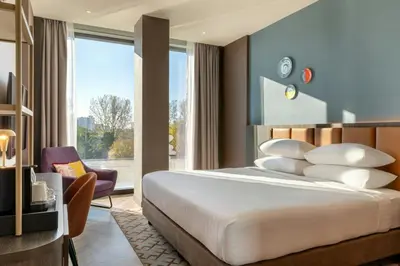 a bedroom with a large bed and a large window at Corendon Amsterdam New-West, a Tribute Portfolio Hotel in Amsterdam