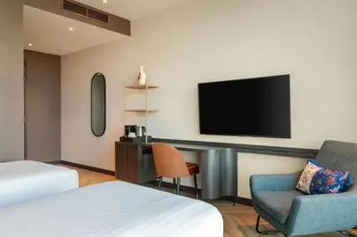 a hotel room with a tv and a bed and a chair at Corendon Amsterdam New-West, a Tribute Portfolio Hotel in Amsterdam