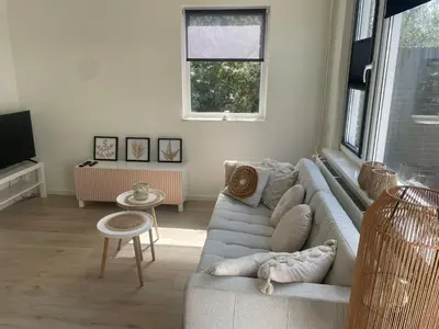 a living room with a couch and a tv at Torensduin aan zee in Egmond aan Zee