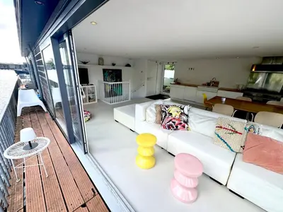 a living room with a white couch on a deck at Houseboat PURE II in Vreeland