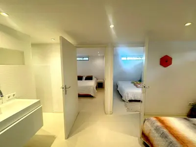 a bathroom with two beds and a bathroom with a sink at Houseboat PURE II in Vreeland