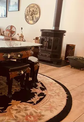 a living room with a stove and a rug at Stunning Island Home with African Asian Vibe in Oude Meer