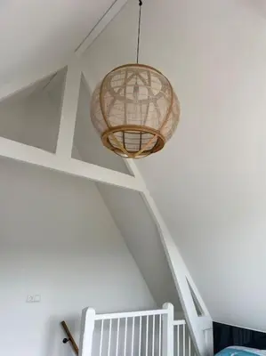 a room with a crib and a light hanging from a ceiling at Wijk aan Zee de Wilde Roos in Wijk aan Zee