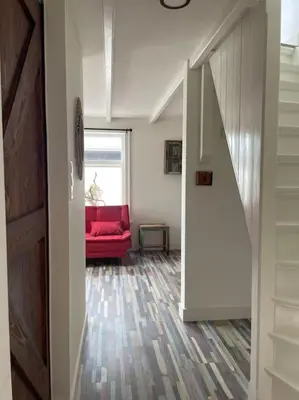 a living room with a red couch and a window at Wijk aan Zee de Wilde Roos in Wijk aan Zee