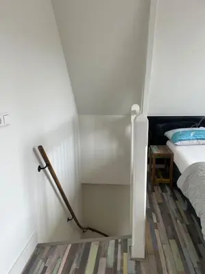 a small bedroom with a bunk bed and a staircase at Wijk aan Zee de Wilde Roos in Wijk aan Zee