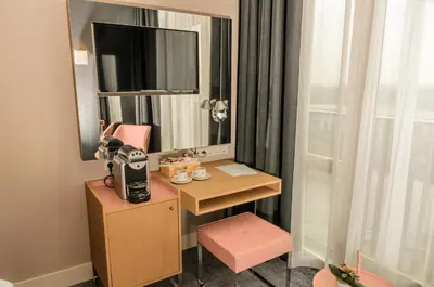 a room with a desk with a mirror and a pink chair at Amadi Panorama Hotel in Amsterdam