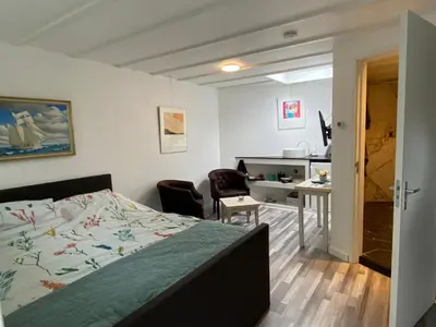 a bedroom with a bed and a desk and a desk at Studio Bergen in Bergen