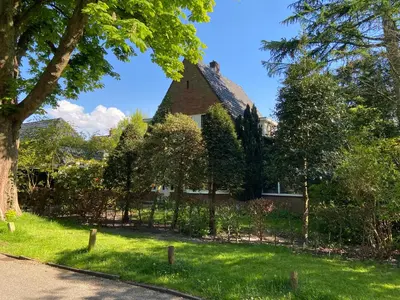 a house with a fence in front of a yard at Studio Bergen in Bergen