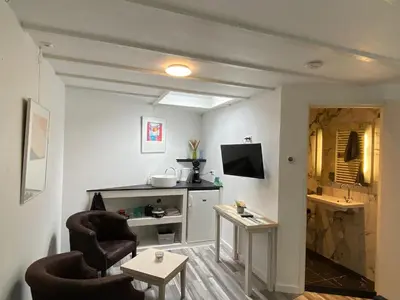 a living room with two chairs and a table at Studio Bergen in Bergen