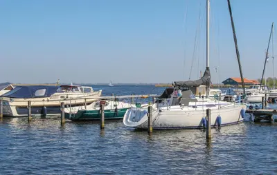 a group of boats docked at a dock in the water at Havenlodge in Uitgeest