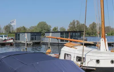 a boat is docked at a dock with a house at Havenlodge in Uitgeest