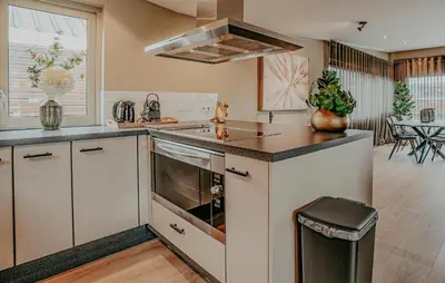 a kitchen with a sink and a stove top oven at Woude in Uitgeest