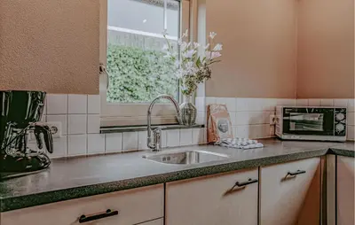 a kitchen counter with a sink and a window at Woude in Uitgeest
