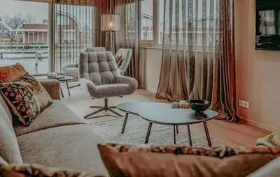 a living room with a couch and a chair and a table at Woude in Uitgeest