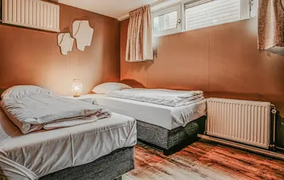 a bedroom with two beds and a window at Woude in Uitgeest