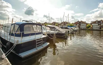 a group of boats docked at a dock in the water at Woude in Uitgeest