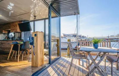 a house with a deck with a table and chairs at Fuut Campi in Uitgeest