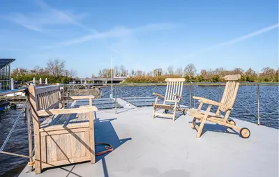 two chairs and a table on the deck of a boat at Fuut Campi in Uitgeest