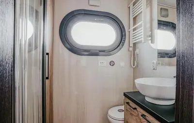 a bathroom with a sink and a toilet and a window at Fuut Campi in Uitgeest