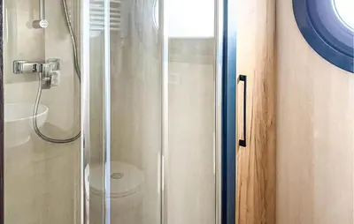 a shower with a glass door in a bathroom at Fuut Campi in Uitgeest