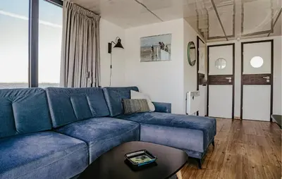 a living room with a blue couch and a table at Fuut Campi in Uitgeest