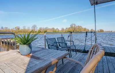 a wooden deck with a table and chairs on a boat at Fuut Campi in Uitgeest